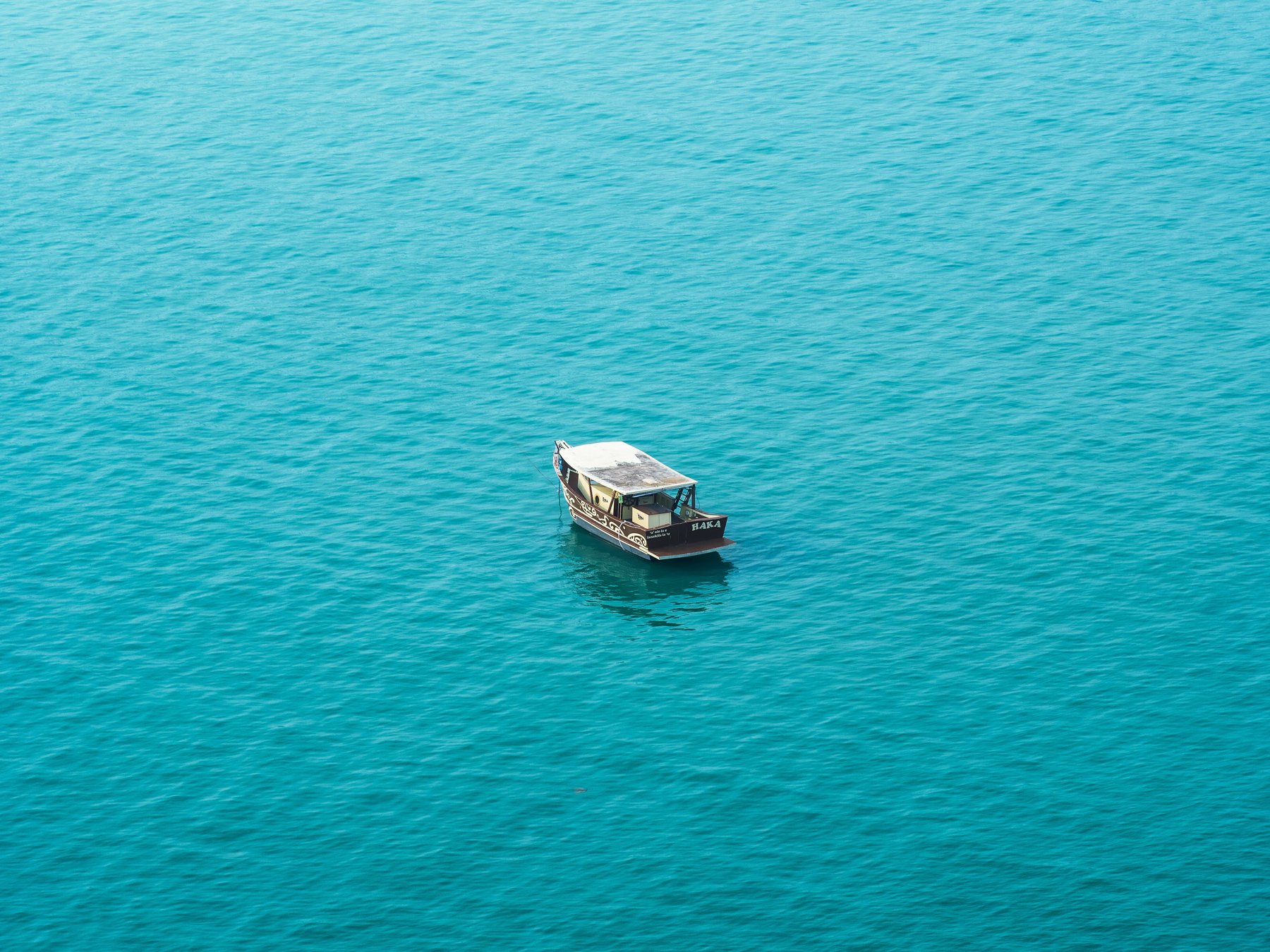 Simulação de fotografia de barco no mar emoldurada em um ambiente com madeira